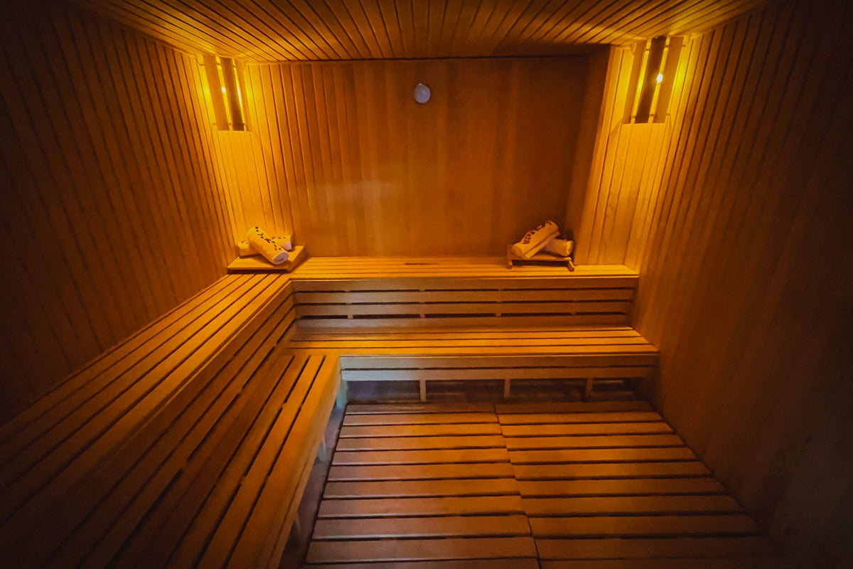 Warm amber-lit wooden sauna cabin interior with tiered benches