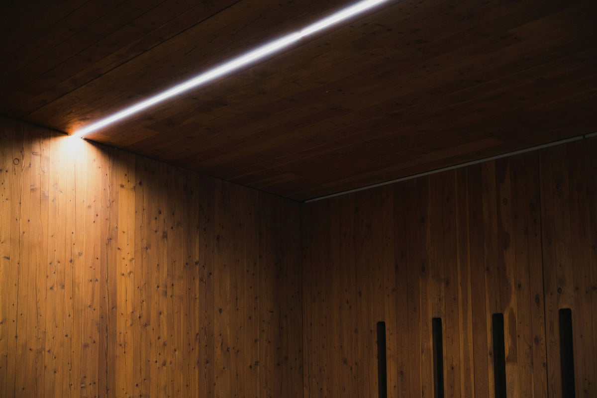 Wood-paneled room with a single line of light along the ceiling edge