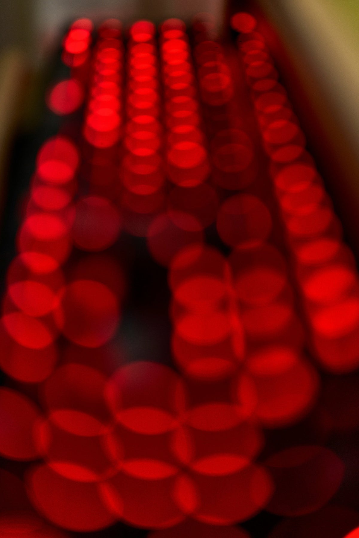 Red LED bokeh macro of a red light therapy panel, out of focus